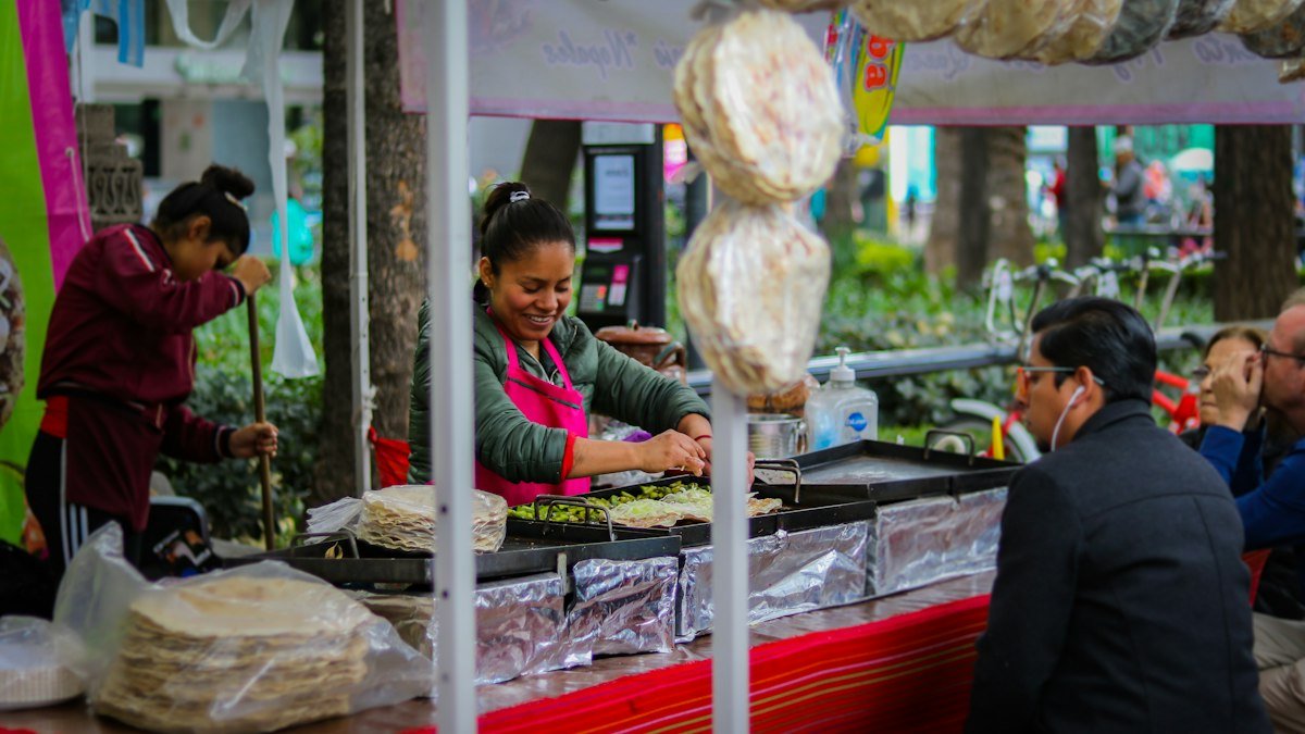 A cook working the window of a street food stand